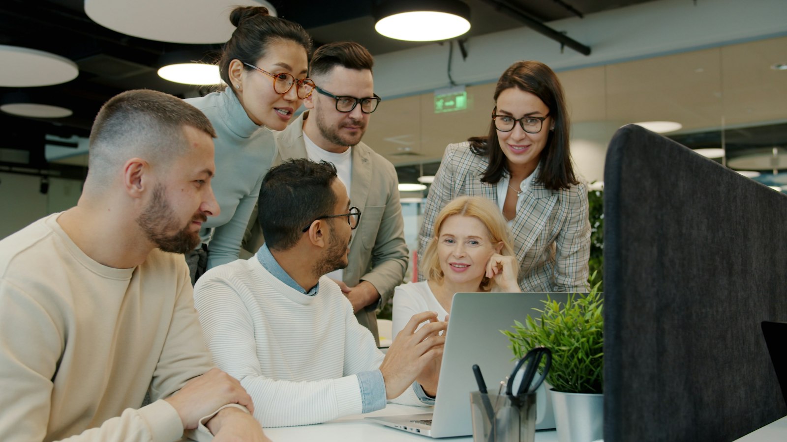 Equipo colaborando alrededor de una laptop