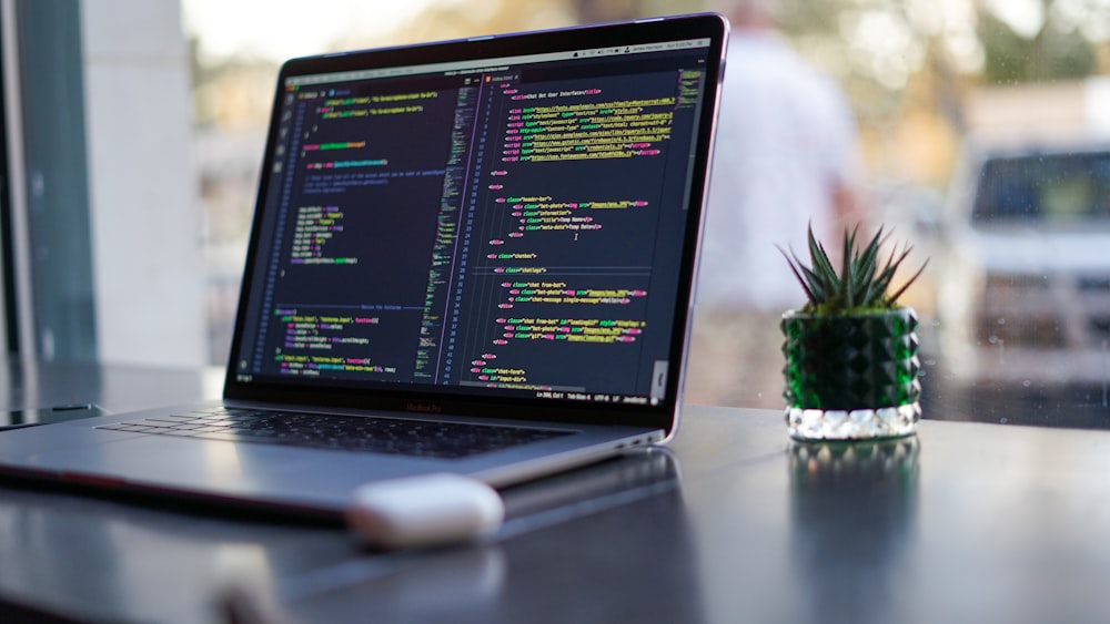 Laptop con código en la pantalla sobre una mesa